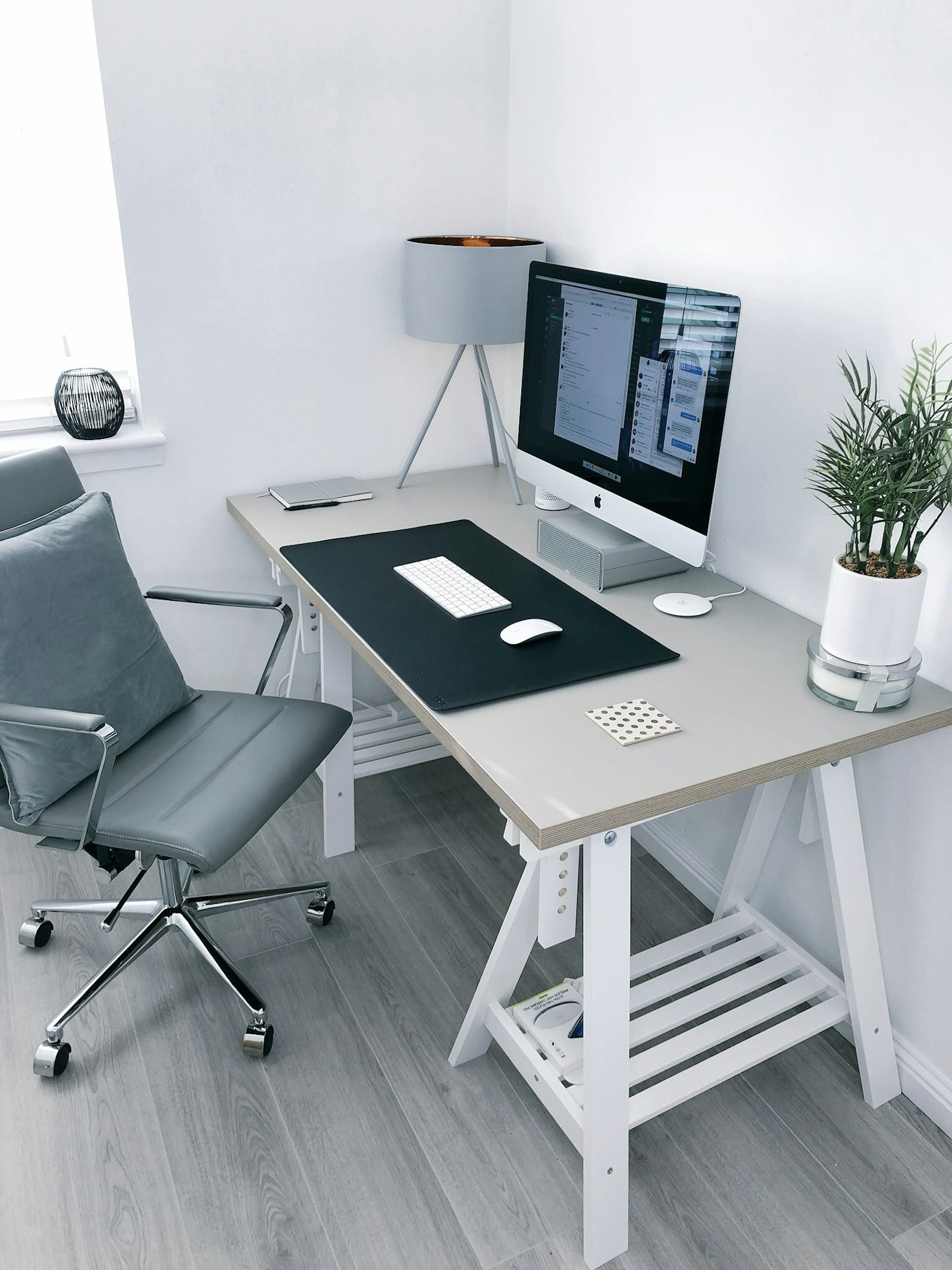 Minimal desk setup with laptop and notebook in natural light.