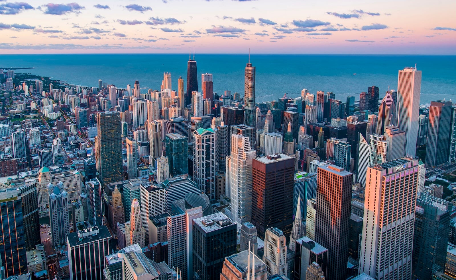 City skyline at dusk with warm light on the buildings.
